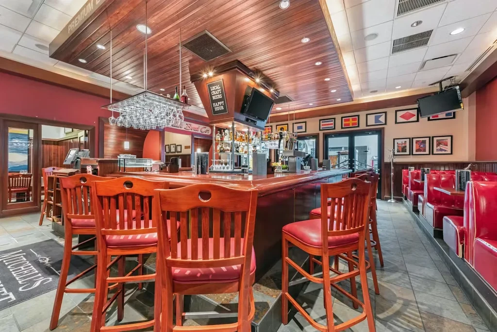 Vibrant restaurant bar with red booths and nautical decor.