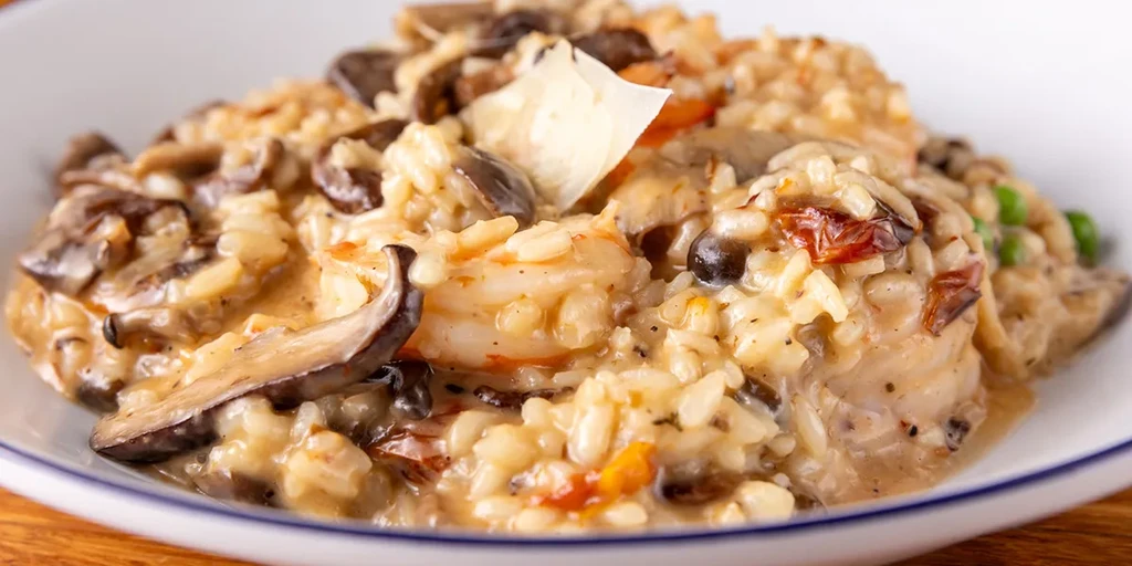 Close-up of creamy mushroom and shrimp risotto topped with Parmesan.