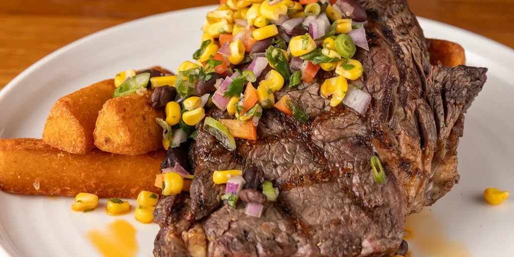 Grilled steak with colorful corn and black bean salsa, and fries.