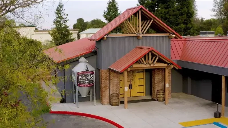 Out of Bounds Brewing Co. building: red roof, grey siding, yellow doors.
