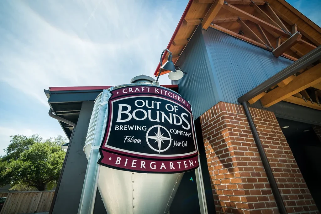Out of Bounds Brewing Company sign on industrial building's silo-like structure.