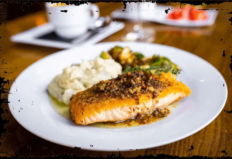 Golden-brown crusted salmon, mashed potatoes, and green vegetables.