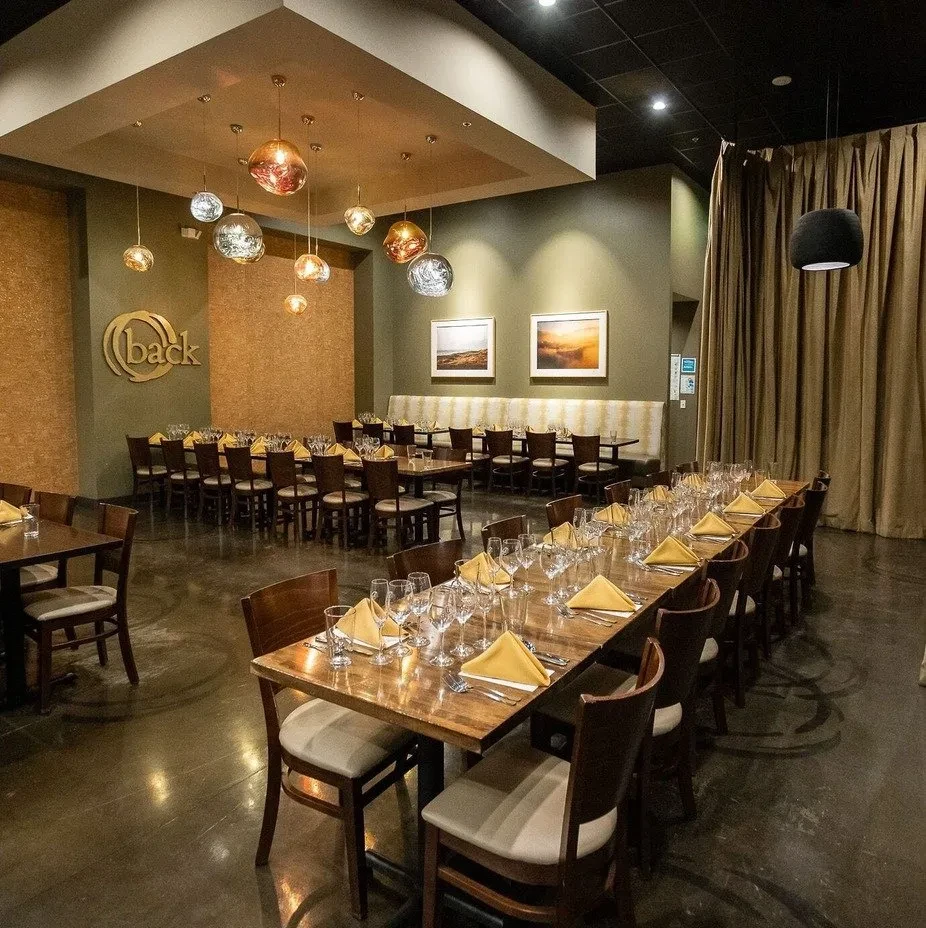 Empty, modern, elegant restaurant dining room with meticulously set tables.