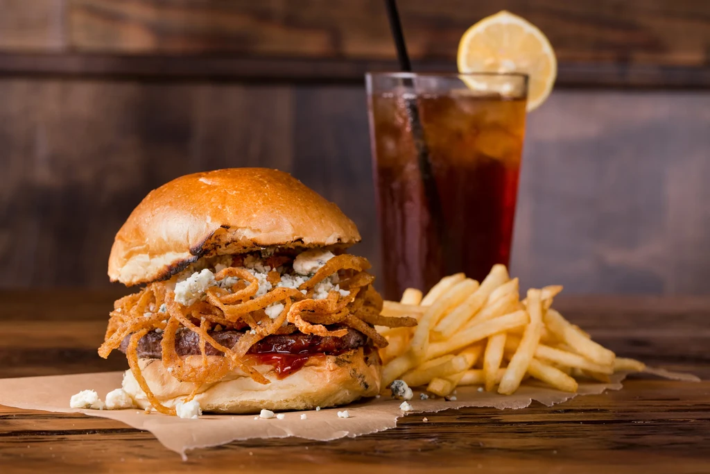 Gourmet burger, blue cheese fries, and iced tea with lemon.