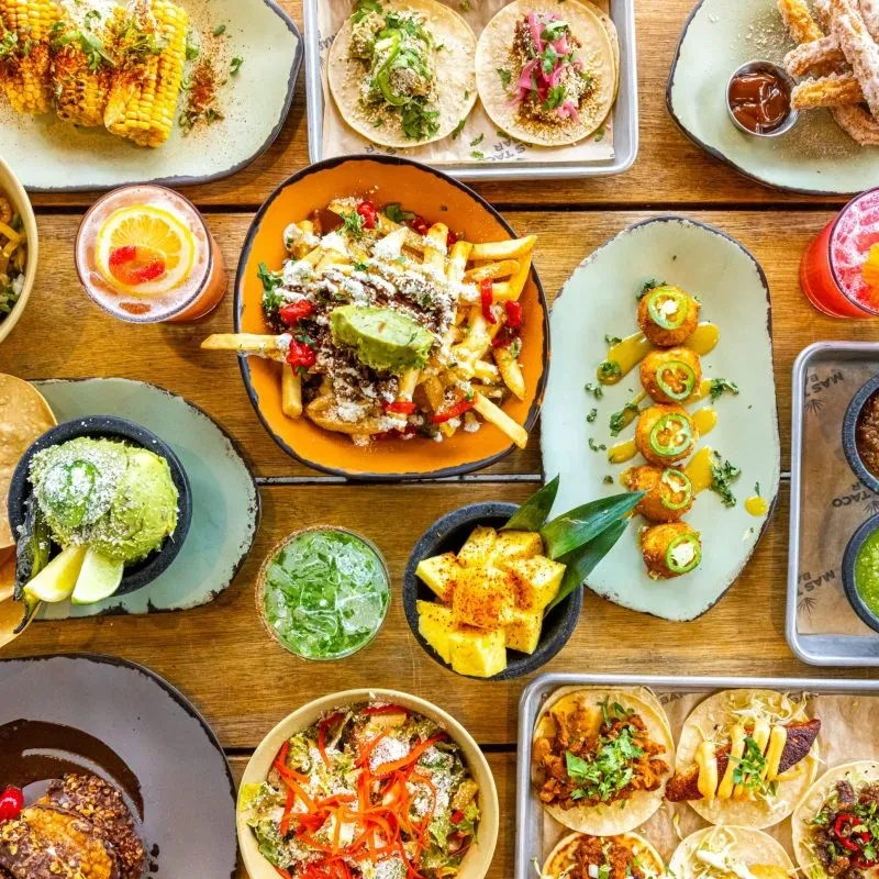 Overhead view of a table full of diverse Mexican dishes and drinks.