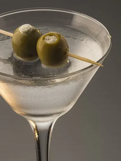 Martini in a frosted glass, with two olives on a toothpick.