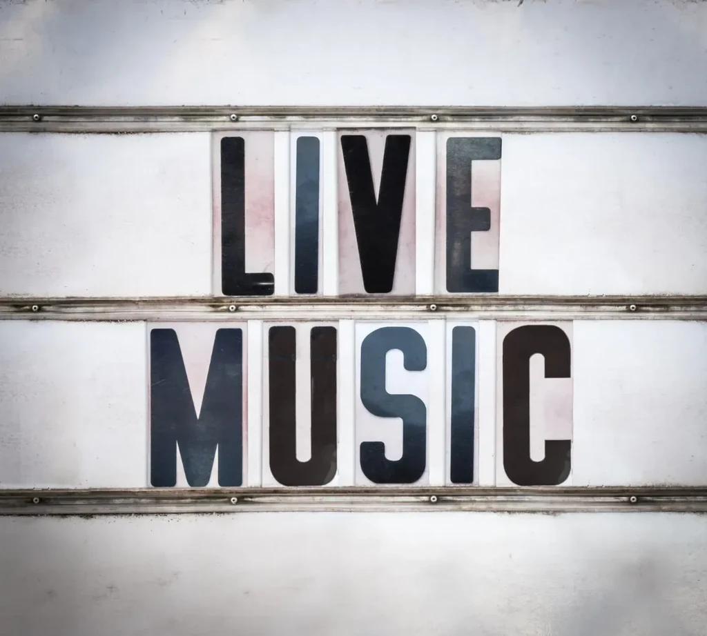 Distressed marquee sign displaying "LIVE MUSIC" on two rails.