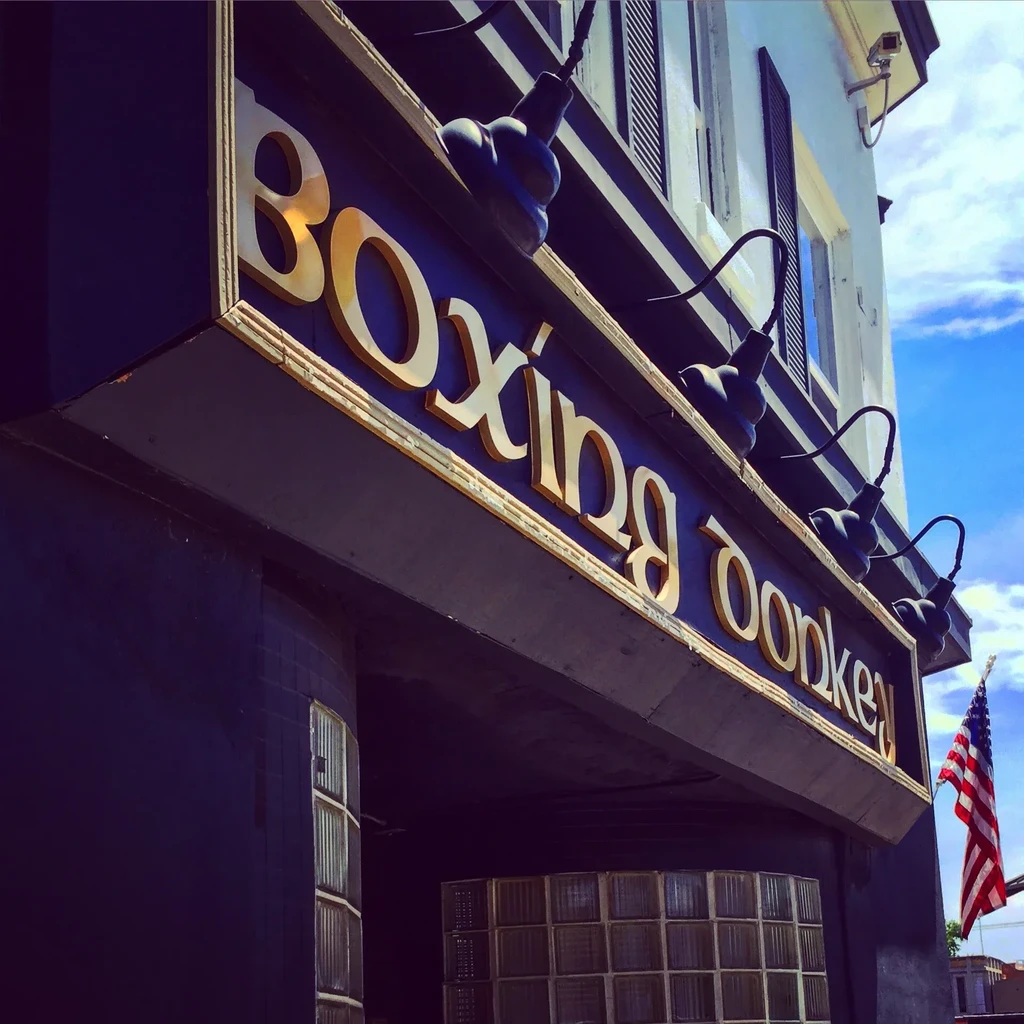 Ornate 'Boxing Donkey' sign with golden letters and boxing glove decor.