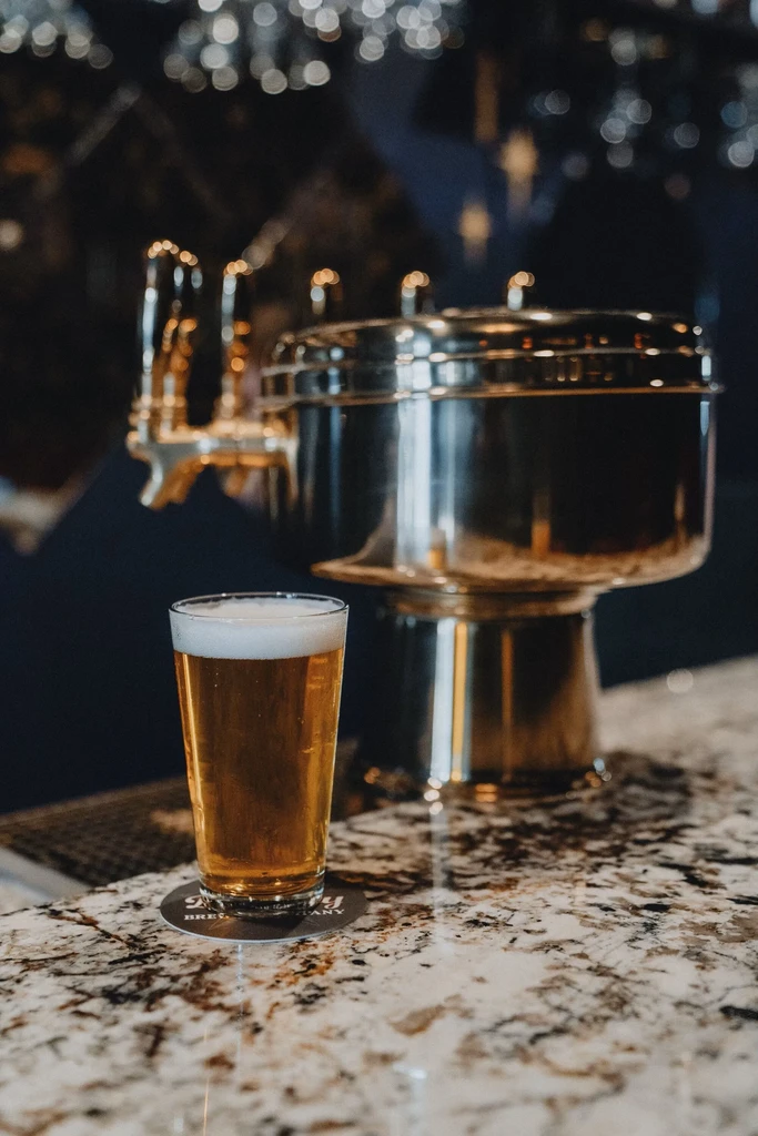 Pint glass of amber beer on a speckled granite bar.