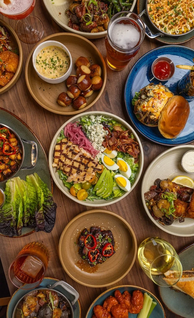 Overhead shot of diverse food and drinks on a wooden table.