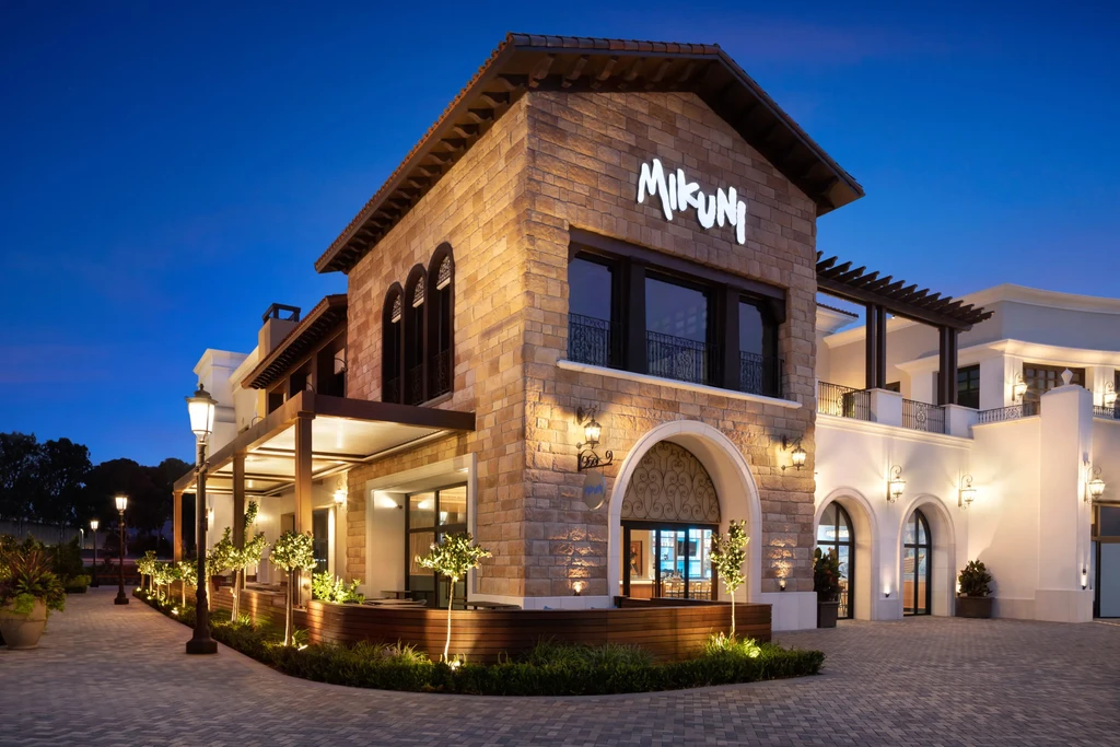 Tuscan-style Mikuni restaurant exterior at dusk with warm lights.