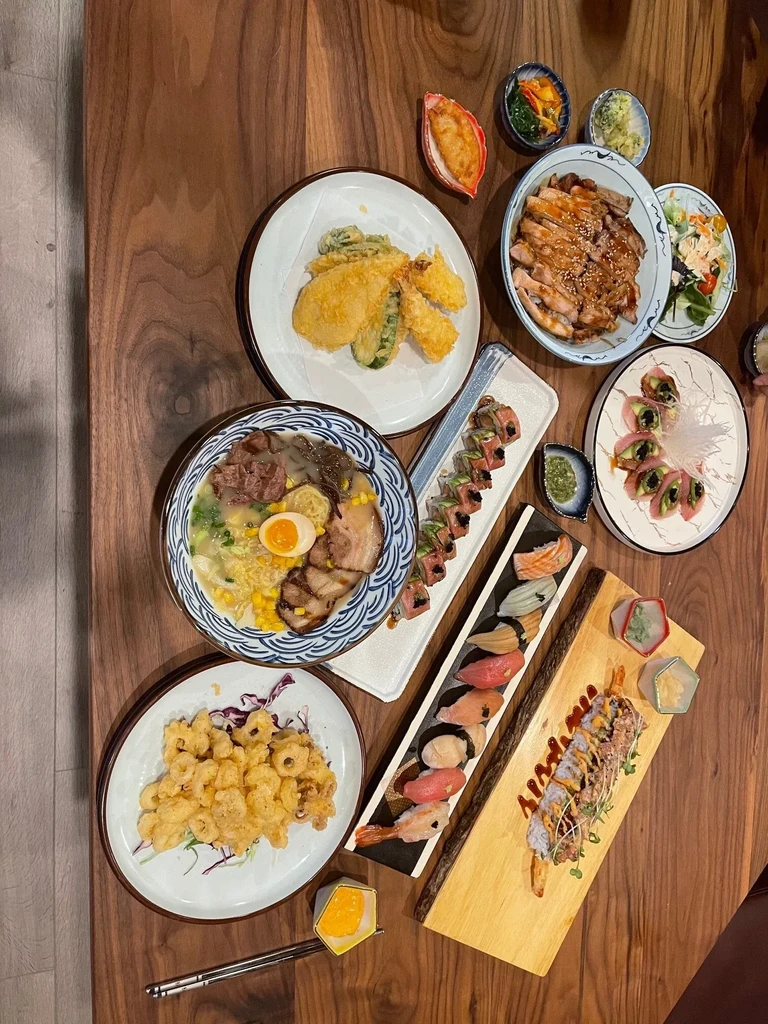 Assorted Japanese dishes including sushi, tempura, and ramen on a table.