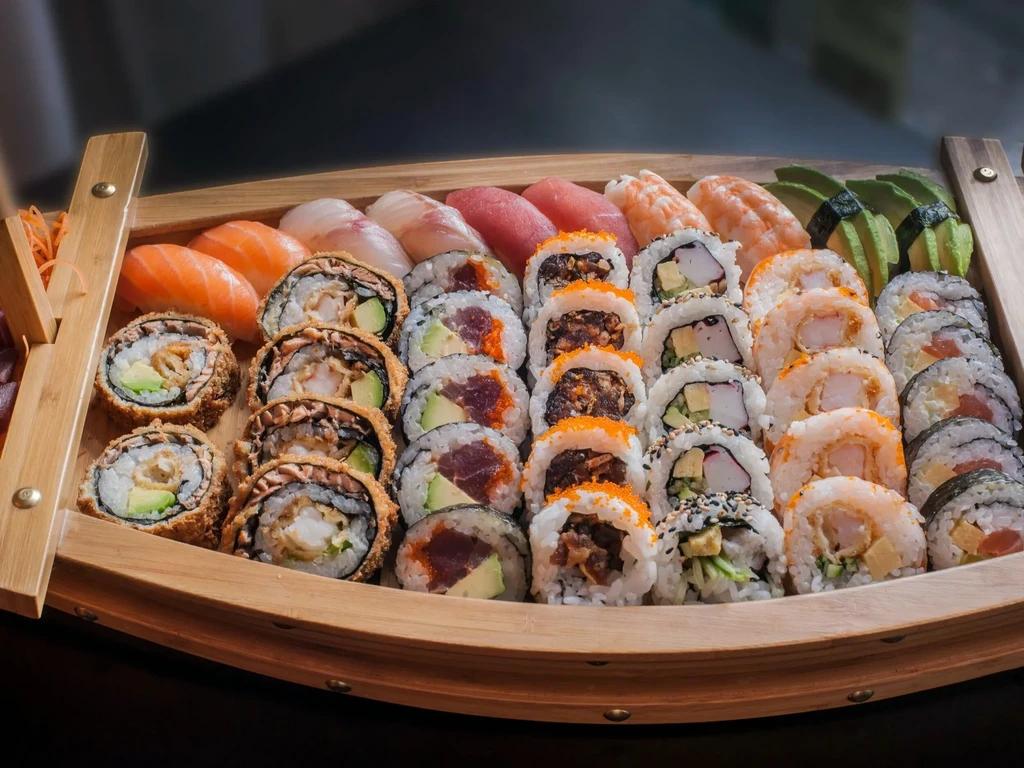 Meticulously arranged sushi and sashimi on a traditional wooden boat.