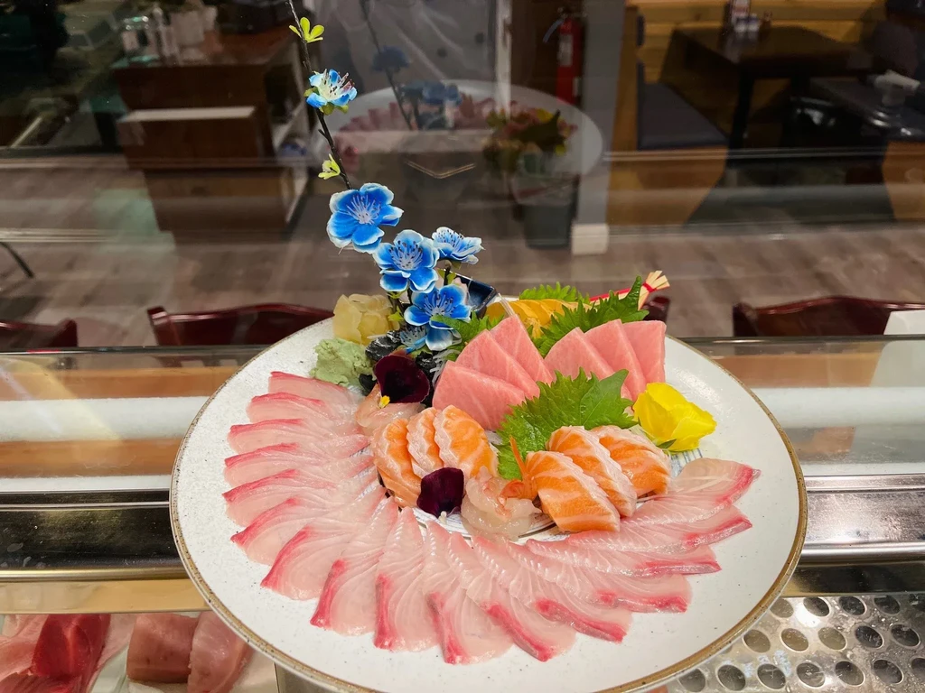 Assorted sashimi platter with tuna, salmon, white fish, and garnishes.