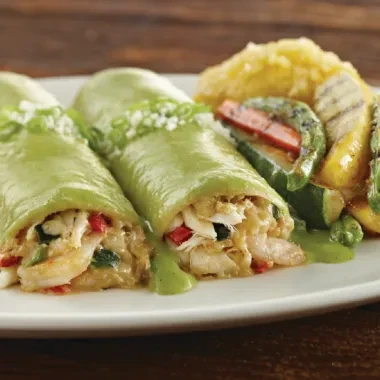Green-wrapped seafood crepes with green sauce, grilled zucchini, and rice.