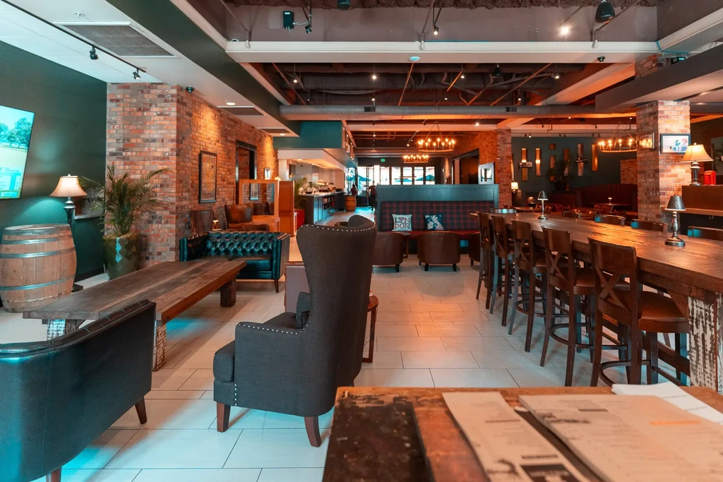 Restaurant interior with exposed brick, industrial lighting, and rustic wood furniture.
