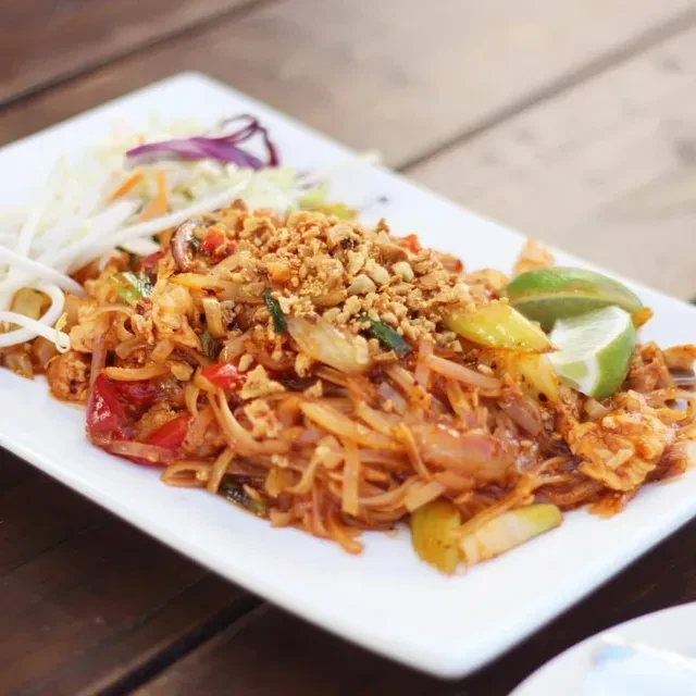 Pad Thai with noodles, egg, protein, peanuts, and lime.