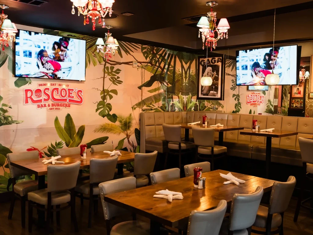 Roscoe's Bar & Burgers interior features tropical mural, TVs, and eclectic decor.