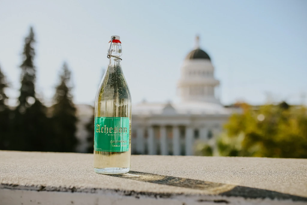 Acheron Wine Company bottle on a ledge with a domed capitol building.