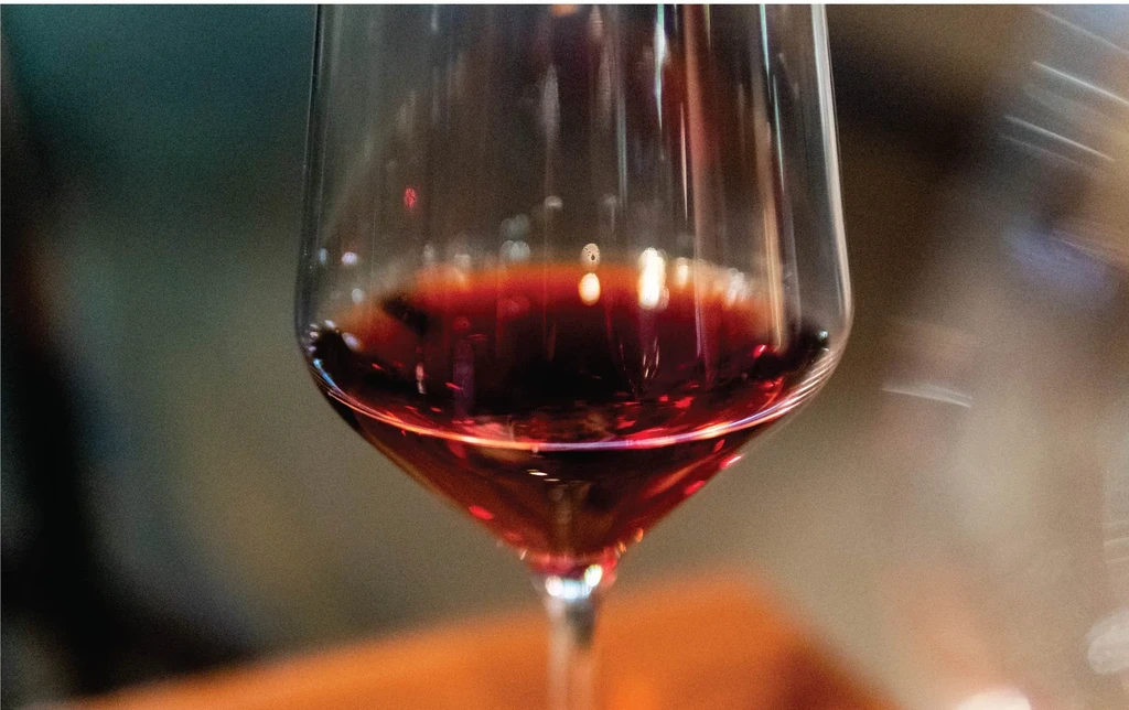 Close-up of a wine glass filled with ruby red wine.