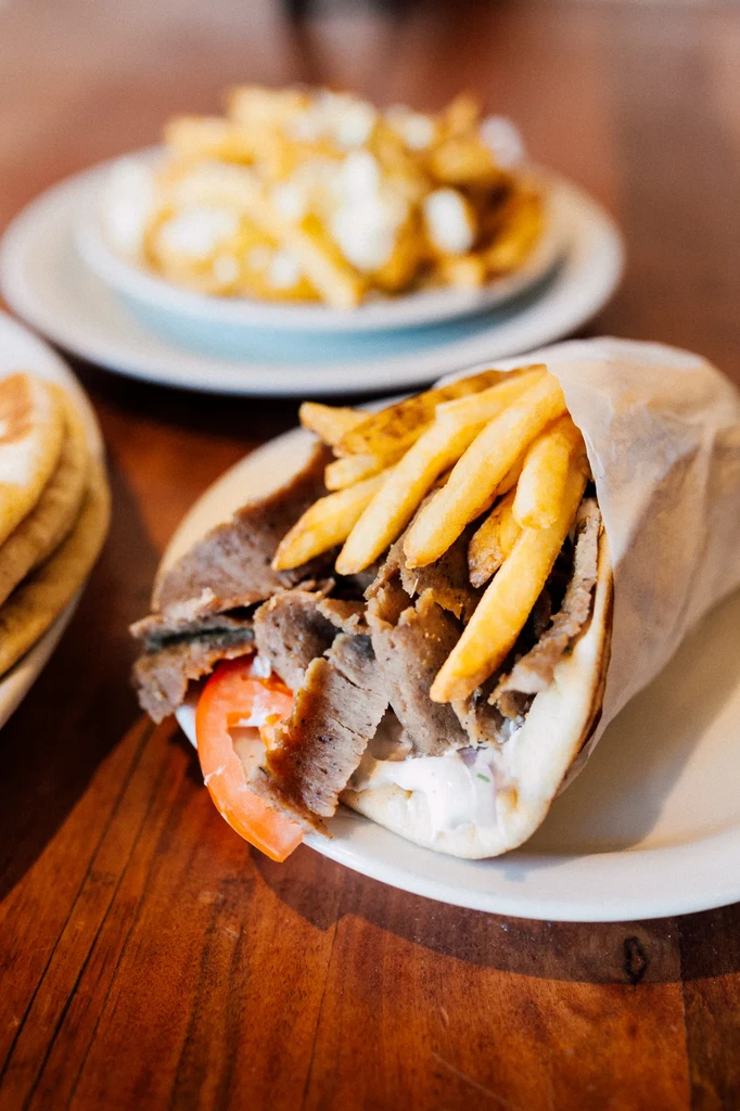 Large meat wrap with fries, tomato, red onion, and poutine.