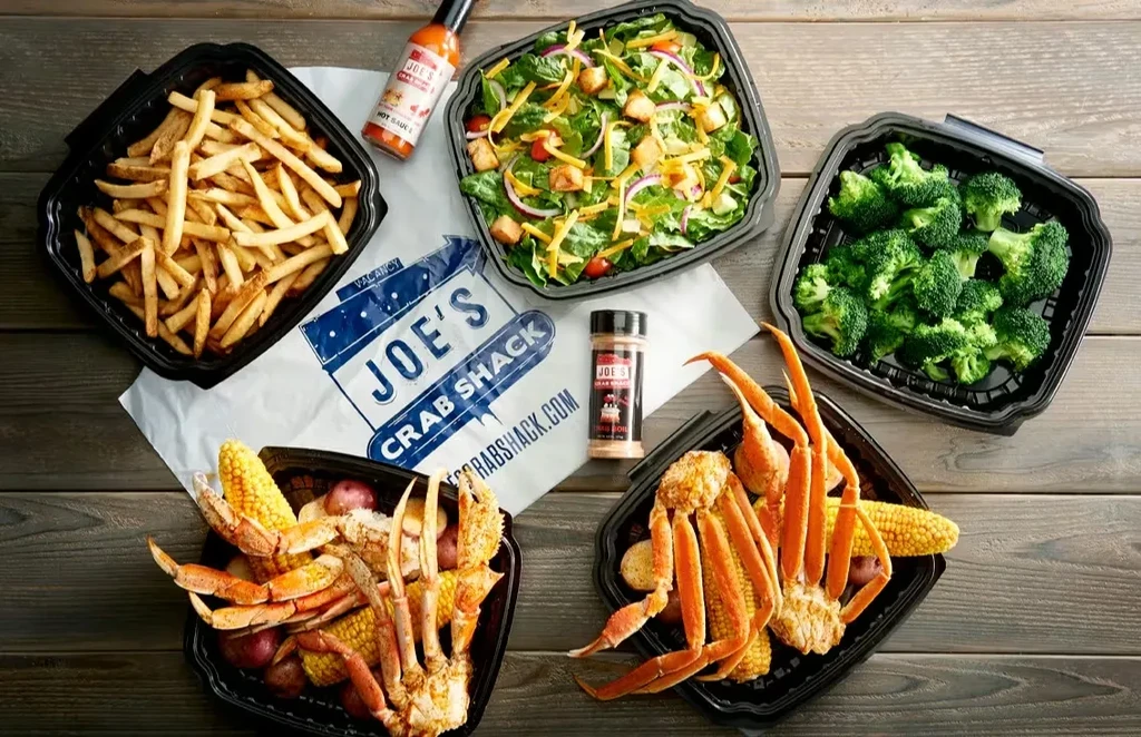 Joe's Crab Shack takeout meal: crab legs, fries, salad, corn, potatoes.