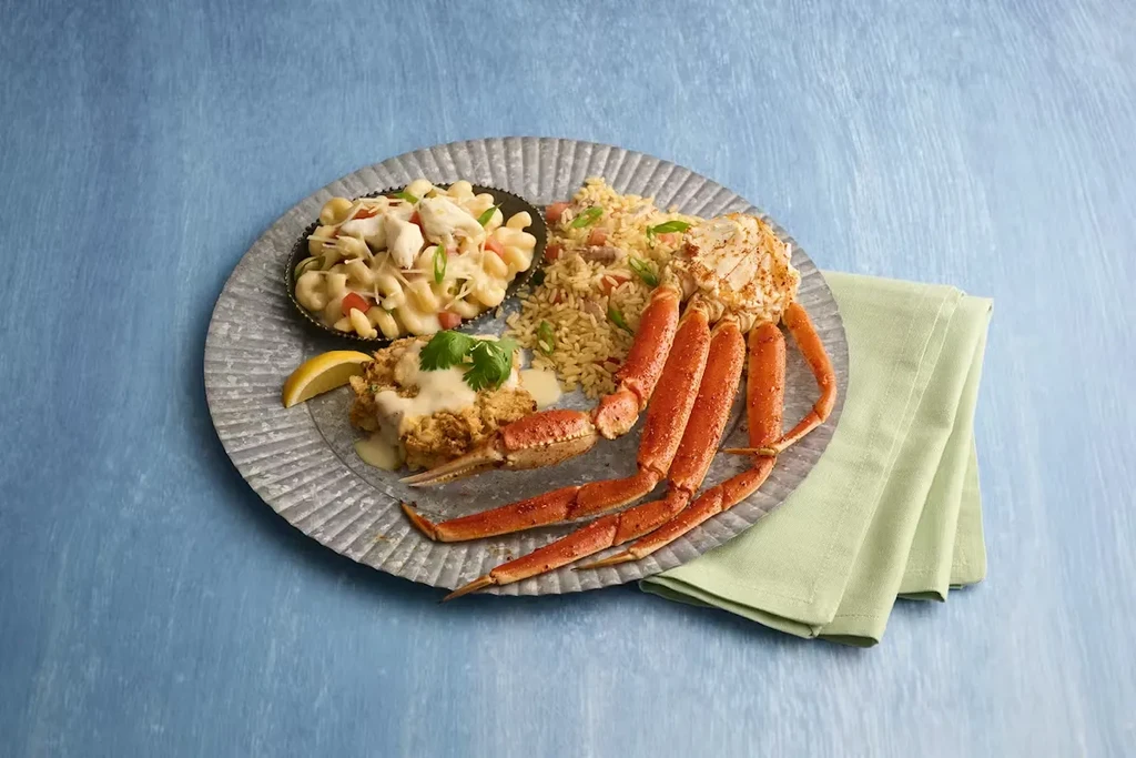 Platter with snow crab legs, crab cake, crab rice, and crab macaroni.