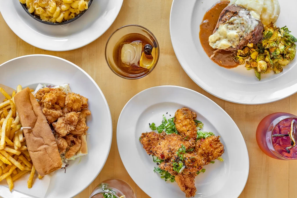 Overhead shot of a table with various restaurant meals and drinks.