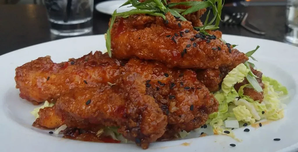 Glistening Korean fried chicken with sweet and spicy sauce, sesame, scallions.