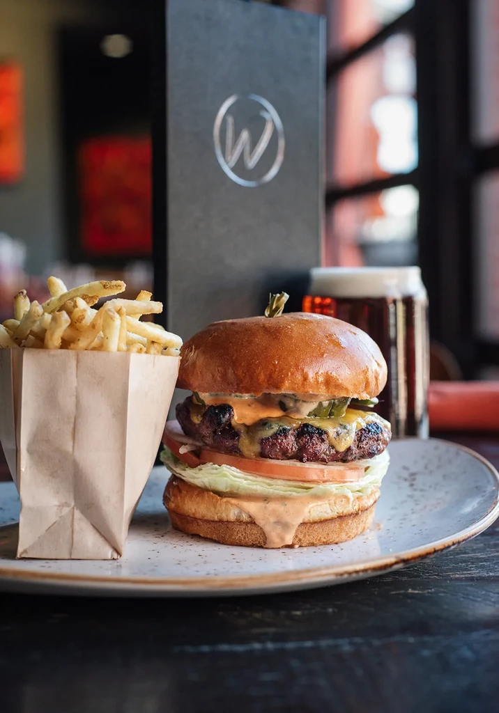 Classic cheeseburger with fries on a plate in a casual restaurant.