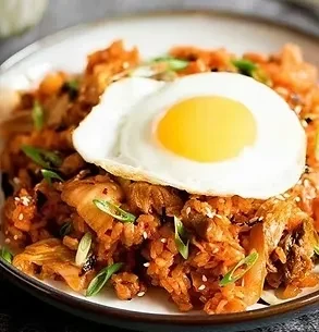 Kimchi fried rice with sunny-side up egg, green onions, and sesame seeds.