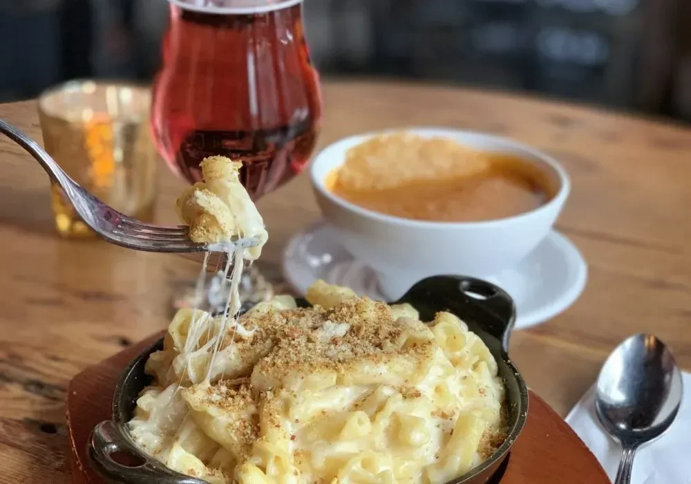 Skillet mac and cheese with cheese pull, plus soup and a drink.