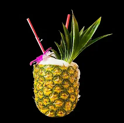 Tropical cocktail served in a fresh pineapple with two straws