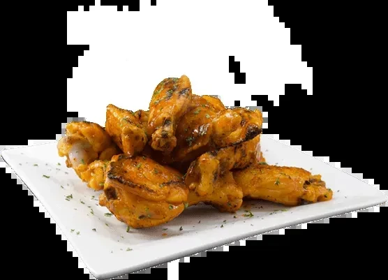 Glazed golden-brown chicken wings with green herbs on a white plate.