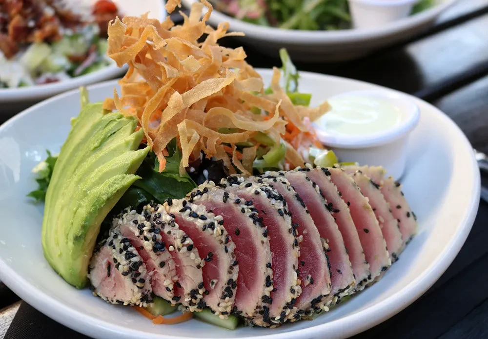 Rare seared sesame-crusted tuna salad with avocado and wontons.