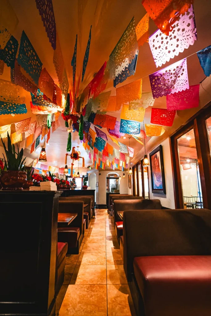 Festive Mexican restaurant interior with colorful papel picado canopy.