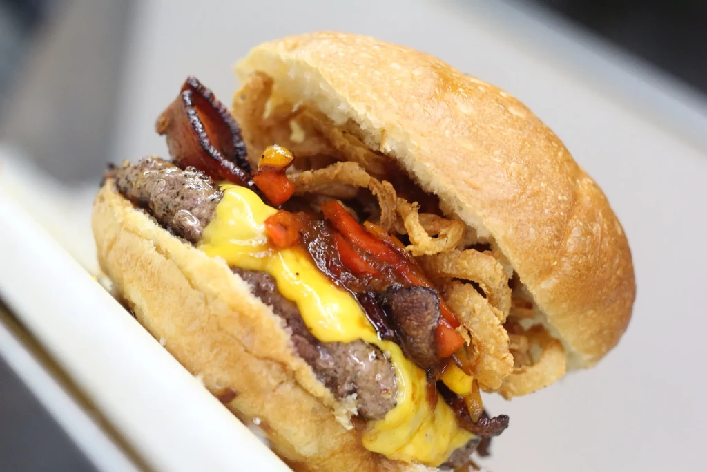 A substantial double-patty burger layered with cheese, bacon, and crispy onions.
