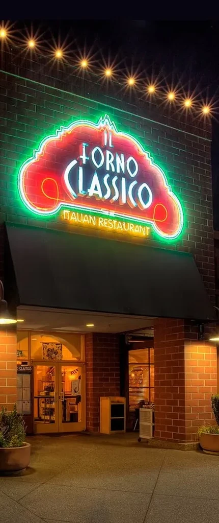 Illuminated neon sign of IL FORNO CLASSICO Italian restaurant at night.