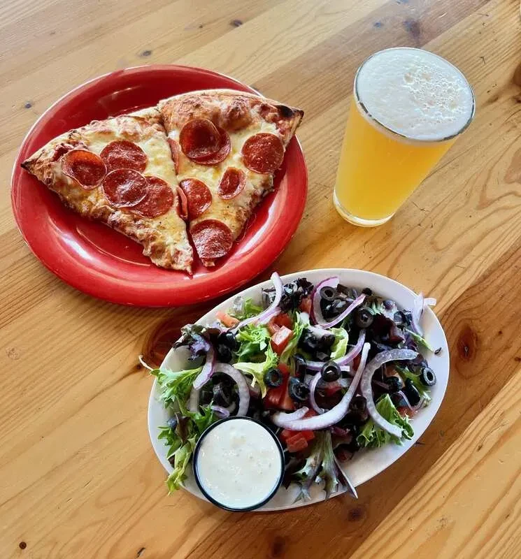 Overhead: pepperoni pizza, green salad, and frothy drink.