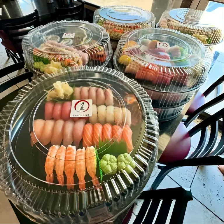Sushi and sashimi in plastic containers with a BANZAUSHI label.