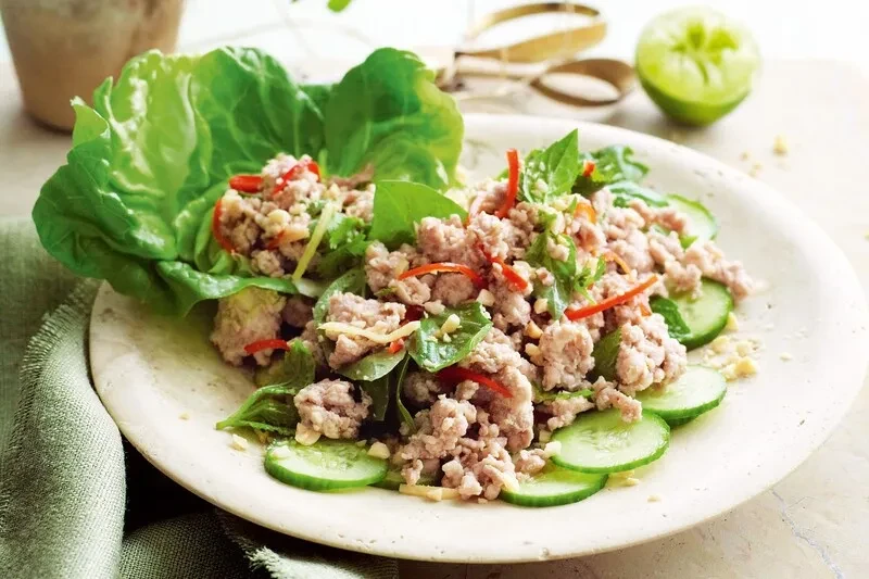Larb-style minced meat salad with herbs, chili, lettuce cups, cucumber.