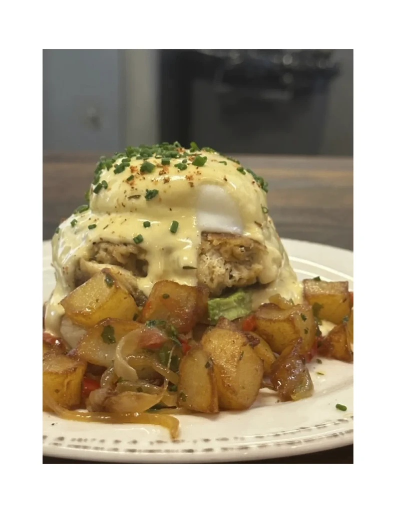 Stacked eggs Benedict variation on savory cake with roasted potatoes.