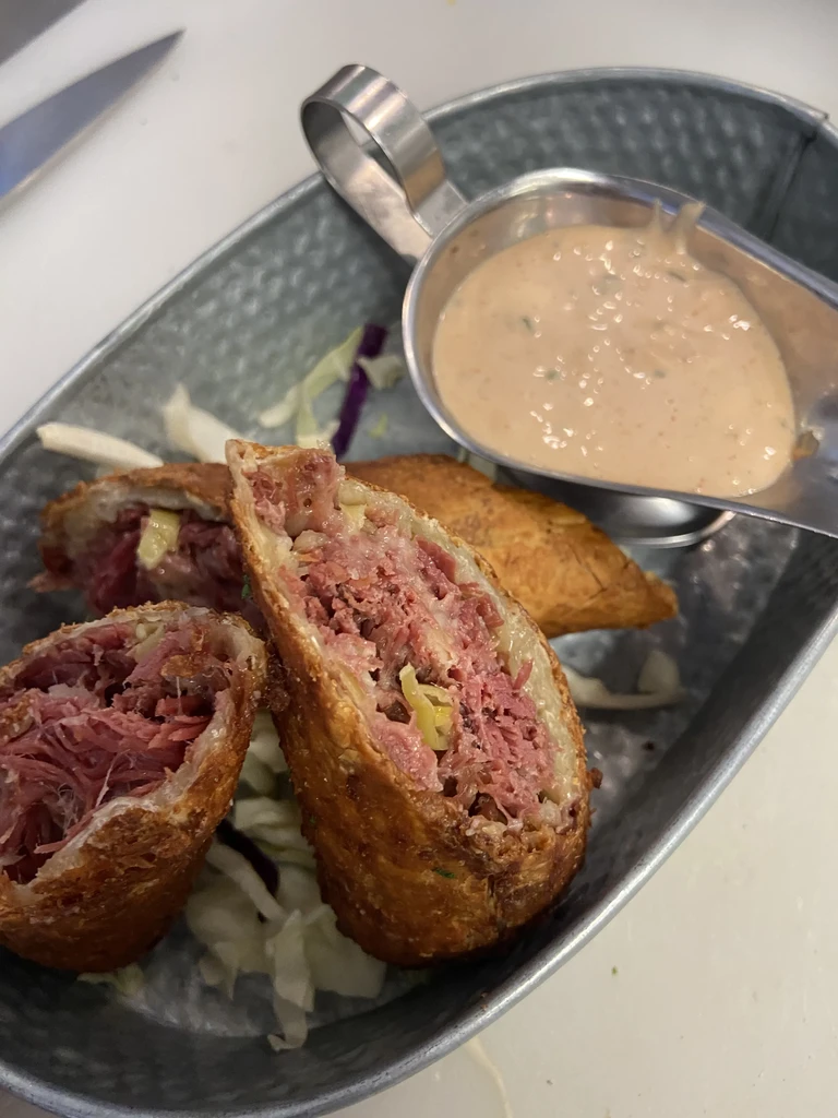 Crispy fried rolls filled with meat and cabbage, served with dipping sauce.