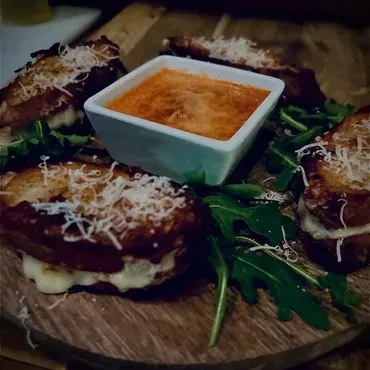 Grilled cheese bites with melted cheese and a tomato dipping sauce.