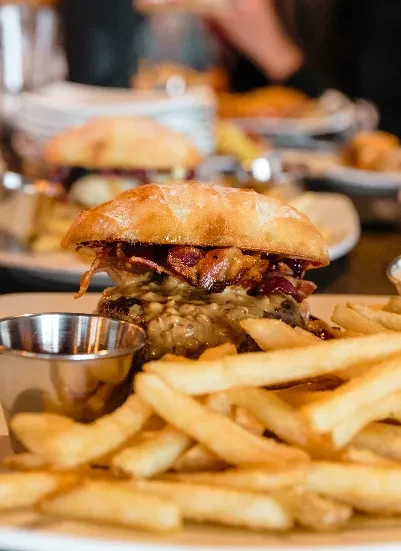 Gourmet burger with thick patty, melted cheese, crispy bacon, and fries.