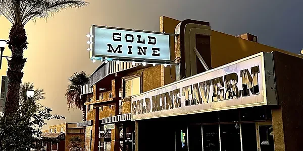 Exterior of Gold Mine Tavern building with lit marquee sign