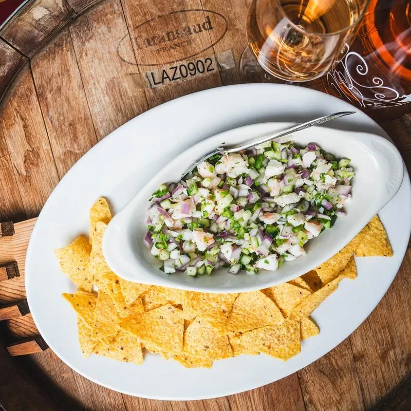 Shrimp ceviche and chips on a Euransaud wine barrel, with wine.