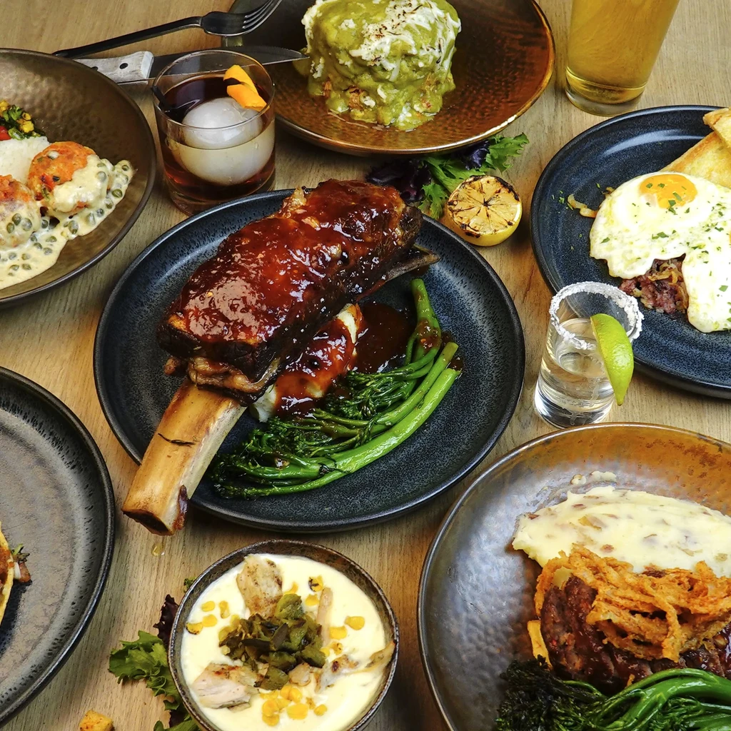 Flat lay: short rib, eggs, cocktails, and various other restaurant dishes.