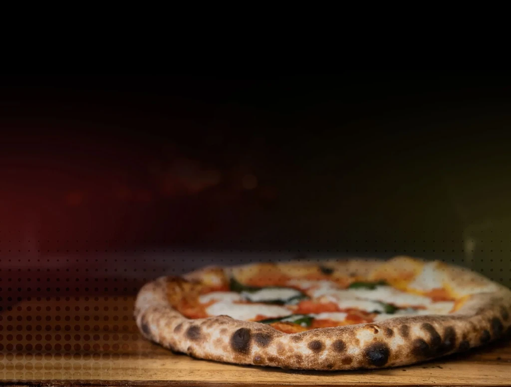 Neapolitan Margherita pizza with bubbly, charred crust on wood.