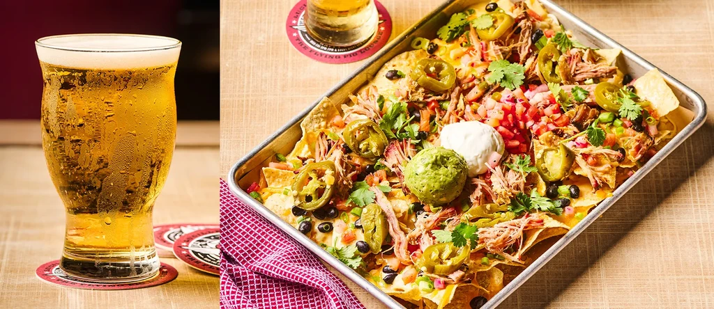 Frosty beer and loaded nachos with meat, cheese, guacamole, sour cream.